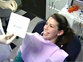 The patient's smile is revealed after undergoing teeth whitening.