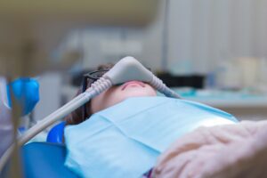 Little girl getting Inhalation Sedation while teeth treatment at dental office