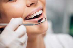 dentist using a mirror to look at a patients fillings