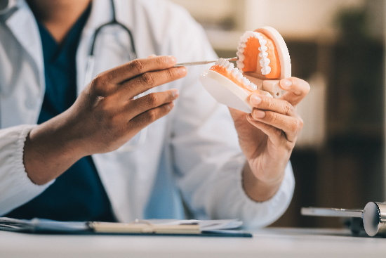 doctor modeling a denture to a patient in Houston